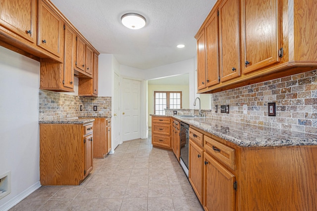 kitchen featuring a sink, black dishwasher, tasteful backsplash, light stone countertops, and brown cabinetry