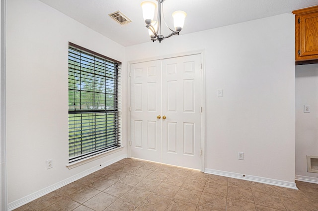 unfurnished dining area featuring a chandelier and baseboards
