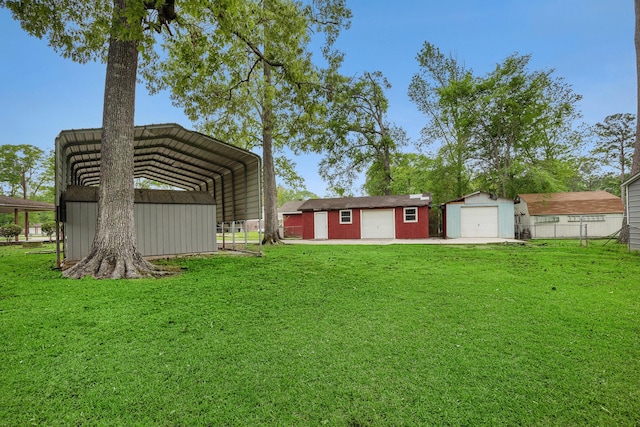 view of yard with an outdoor structure, a detached carport, and a garage