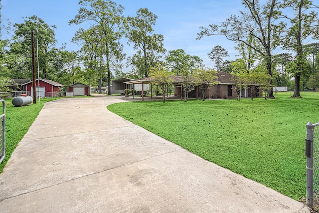 view of front of house with concrete driveway, a detached carport, and an outdoor structure