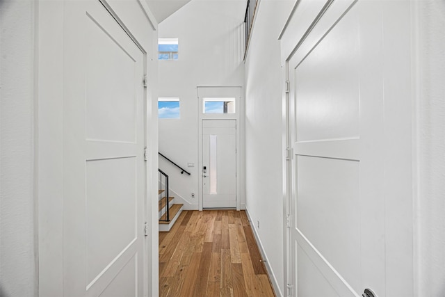 3402 Asher Landing Ln, Houston, TX 77080 - doorway to outside with baseboards, light wood-type flooring, and stairs
