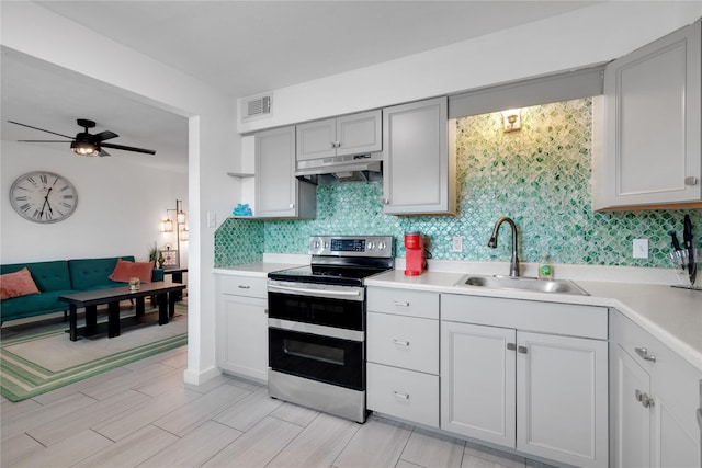 2002 27th St, Galveston, TX 77550 - kitchen with a sink, visible vents, range with two ovens, light countertops, and under cabinet range hood