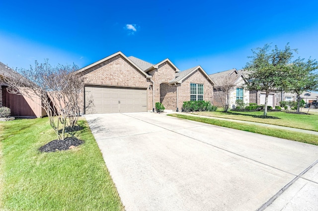 23818 Northwood Terrace Ln, Katy, TX 77493 - french provincial home featuring brick siding, a front yard, concrete driveway, and an attached garage