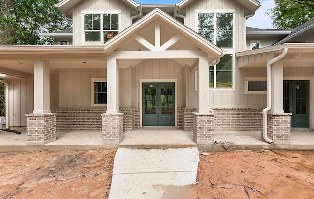 40715 Pipestone Rd, Magnolia, TX 77354 - view of exterior entry with board and batten siding, french doors, and brick siding