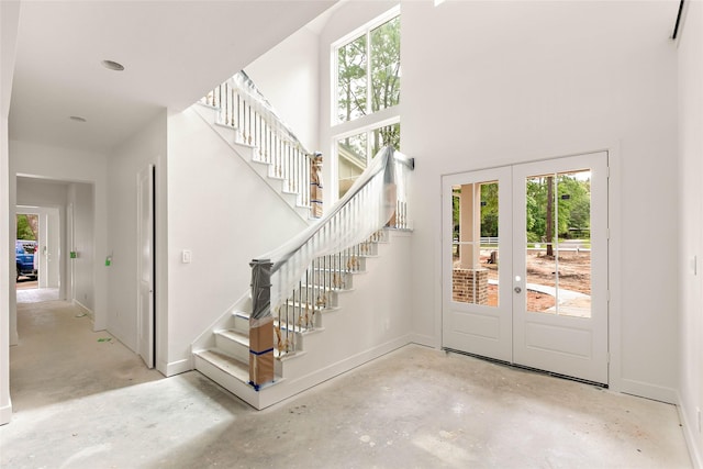 40715 Pipestone Rd, Magnolia, TX 77354 - entrance foyer with a high ceiling, unfinished concrete flooring, french doors, baseboards, and stairs