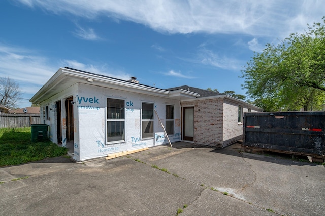 rear view of house featuring a patio and fence