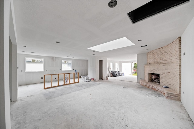 6206 Yarwell Dr, Houston, TX 77096 - unfurnished living room featuring a brick fireplace, a skylight, and a textured ceiling