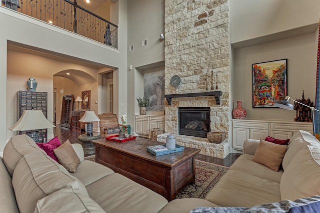 21610 Harbor Water Dr, Cypress, TX 77433 - living area featuring wood finished floors, a towering ceiling, arched walkways, and a fireplace
