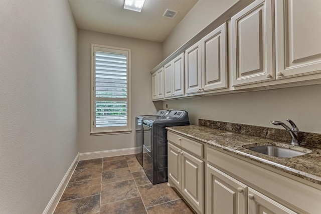 21610 Harbor Water Dr, Cypress, TX 77433 - washroom with washing machine and clothes dryer, baseboards, cabinet space, and dark stone finish floors