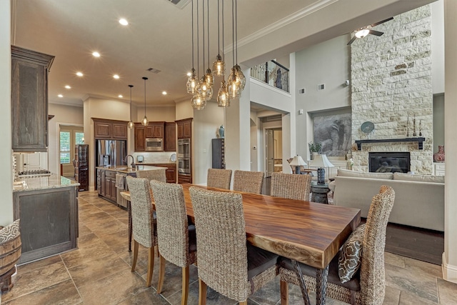 21610 Harbor Water Dr, Cypress, TX 77433 - dining area featuring ornamental molding, a stone fireplace, stone tile flooring, recessed lighting, and a ceiling fan
