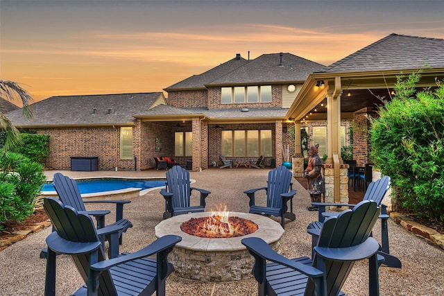 21610 Harbor Water Dr, Cypress, TX 77433 - patio terrace at dusk featuring an outdoor fire pit, an outdoor pool, and a patio area