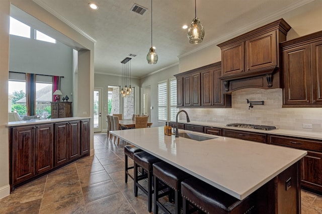 21610 Harbor Water Dr, Cypress, TX 77433 - kitchen featuring crown molding, tasteful backsplash, stainless steel gas cooktop, light countertops, and a chandelier