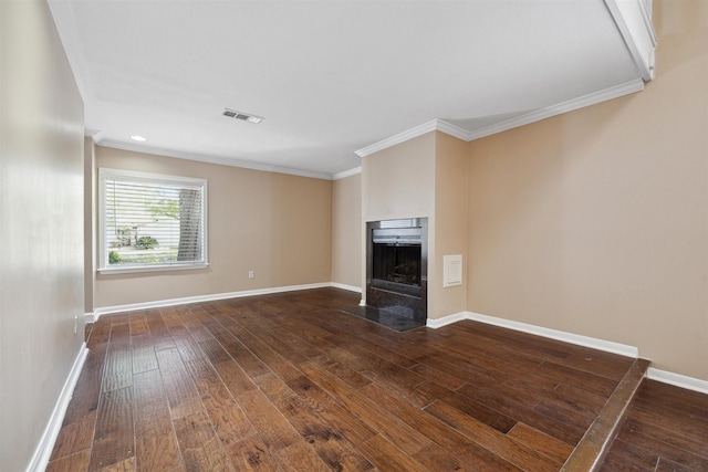 unfurnished living room with crown molding, wood-type flooring, a fireplace with flush hearth, baseboards, and visible vents