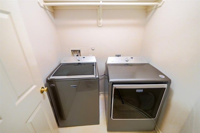 6019 Spanish Oak Dr, Pasadena, TX 77505 - clothes washing area with light tile patterned floors, washer and dryer, and laundry area