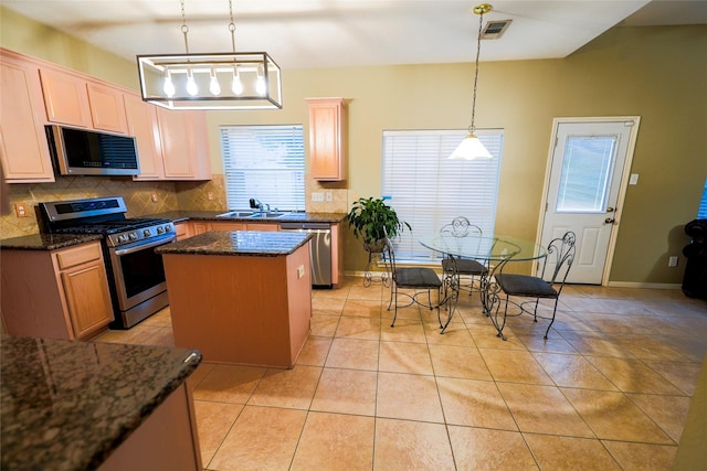 6019 Spanish Oak Dr, Pasadena, TX 77505 - kitchen with stainless steel appliances, visible vents, a sink, a center island, and tasteful backsplash