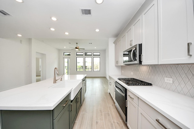 14647 Cedar Elm Ct, Willis, TX 77318 - kitchen featuring appliances with stainless steel finishes, recessed lighting, backsplash, light countertops, and a center island with sink