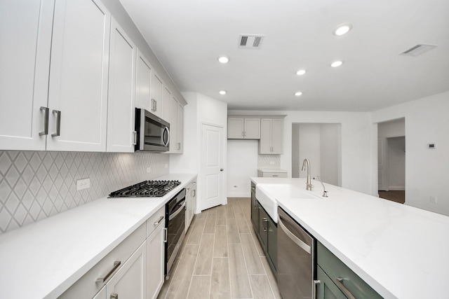 14647 Cedar Elm Ct, Willis, TX 77318 - kitchen featuring stainless steel appliances, recessed lighting, tasteful backsplash, light countertops, and wood tiled floors