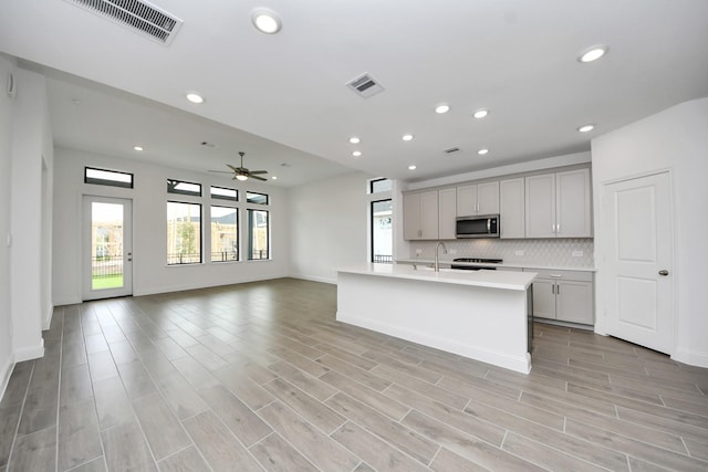 14647 Cedar Elm Ct, Willis, TX 77318 - kitchen featuring stainless steel microwave, gray cabinets, ceiling fan, light countertops, and recessed lighting