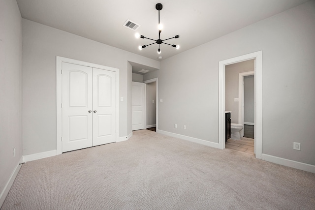 unfurnished bedroom featuring light colored carpet, baseboards, a chandelier, visible vents, and a closet
