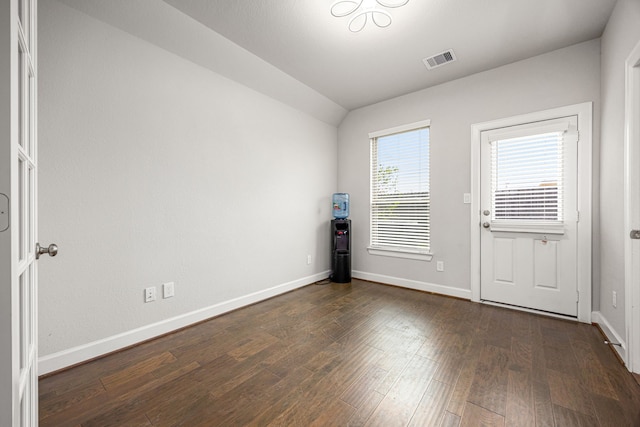 unfurnished room featuring baseboards, dark wood-style flooring, visible vents, and vaulted ceiling