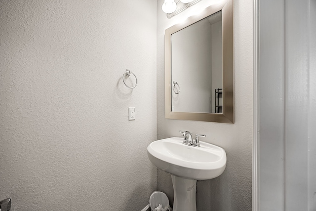 bathroom featuring a sink and a textured wall