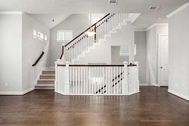 staircase with baseboards, visible vents, wood finished floors, and crown molding