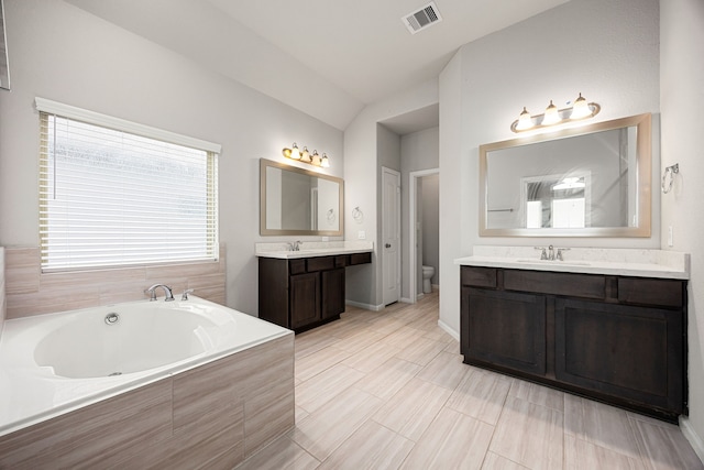 full bath featuring vaulted ceiling, toilet, a sink, a garden tub, and visible vents