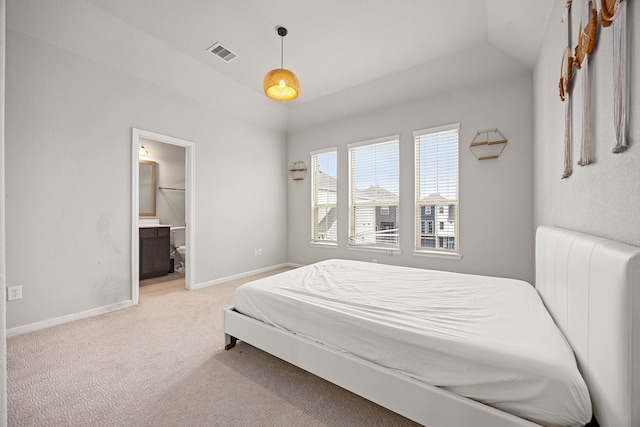 bedroom with vaulted ceiling, baseboards, light colored carpet, and visible vents