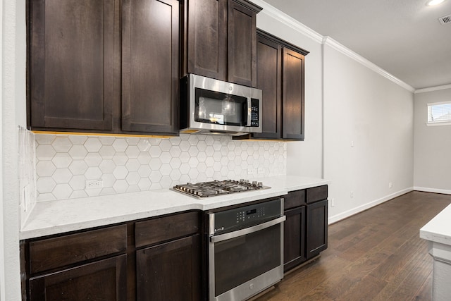 kitchen with backsplash, appliances with stainless steel finishes, dark wood-style floors, ornamental molding, and dark brown cabinets