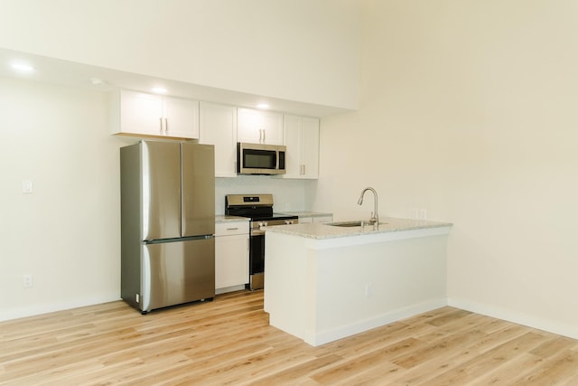 4406 Helen St, Hitchcock, TX 77563 - kitchen with white cabinetry, a peninsula, a sink, and stainless steel appliances