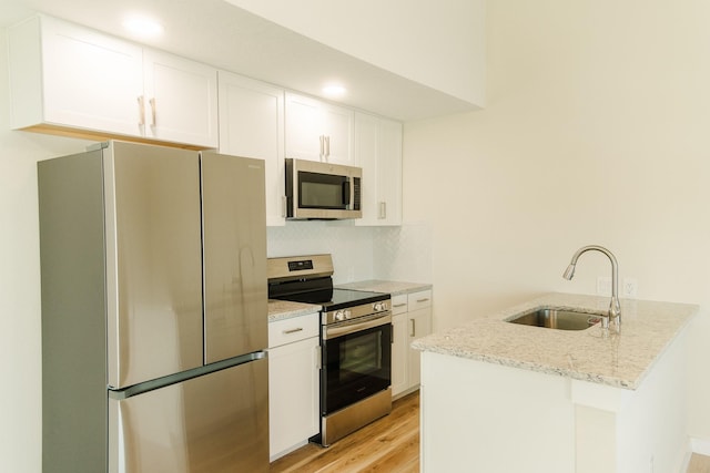 4406 Helen St, Hitchcock, TX 77563 - kitchen featuring stainless steel appliances, backsplash, a sink, white cabinets, and a peninsula