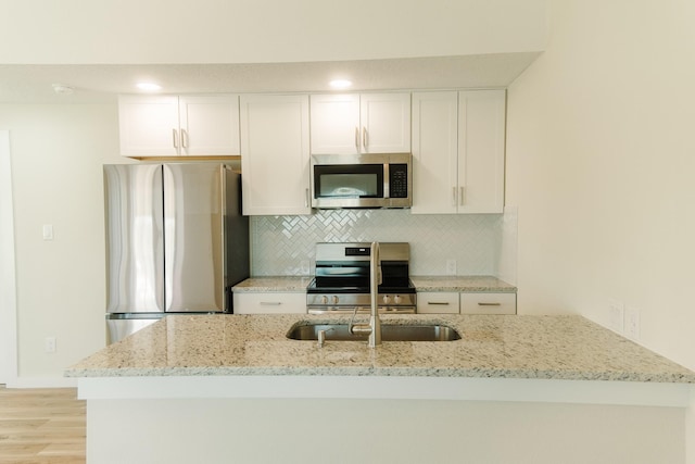 4406 Helen St, Hitchcock, TX 77563 - kitchen with tasteful backsplash, light stone countertops, white cabinets, and stainless steel appliances