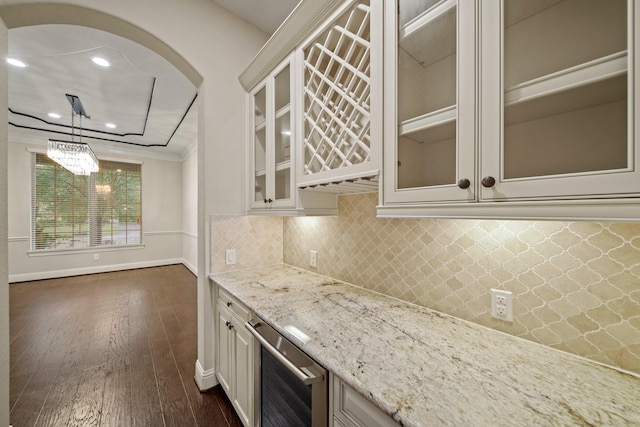 5730 Balcones Ridge Ln, Houston, TX 77059 - kitchen with light stone counters, backsplash, glass insert cabinets, beverage cooler, and dark wood-style flooring