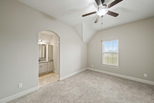 5730 Balcones Ridge Ln, Houston, TX 77059 - unfurnished bedroom with baseboards, light carpet, arched walkways, lofted ceiling, and ensuite bath