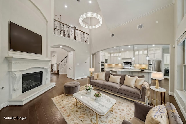 5730 Balcones Ridge Ln, Houston, TX 77059 - living room featuring a premium fireplace, baseboards, visible vents, arched walkways, and dark wood-style flooring