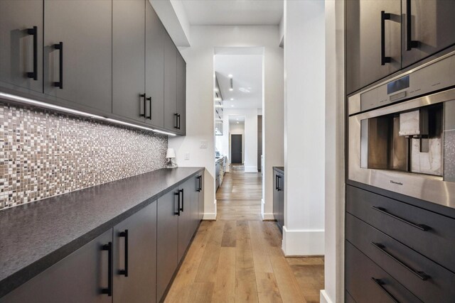 3835 Olympia Dr, Houston, TX 77019 - kitchen with dark countertops, baseboards, light wood finished floors, backsplash, and recessed lighting