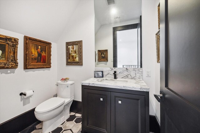 3835 Olympia Dr, Houston, TX 77019 - bathroom with toilet, vanity, tasteful backsplash, baseboards, and vaulted ceiling