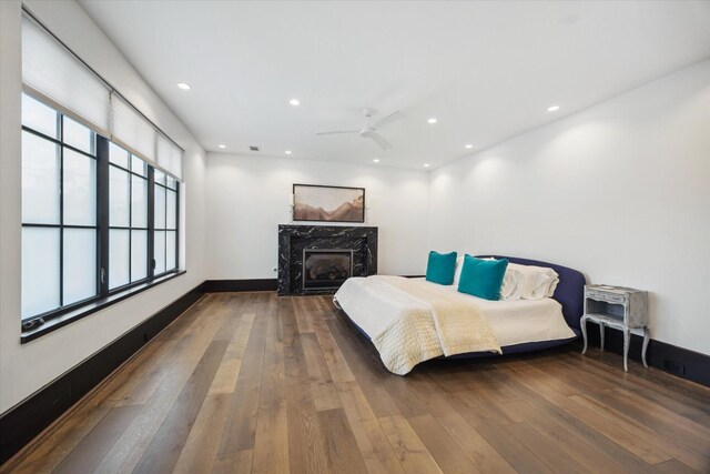 3835 Olympia Dr, Houston, TX 77019 - bedroom with a high end fireplace, wood-type flooring, recessed lighting, ceiling fan, and baseboards
