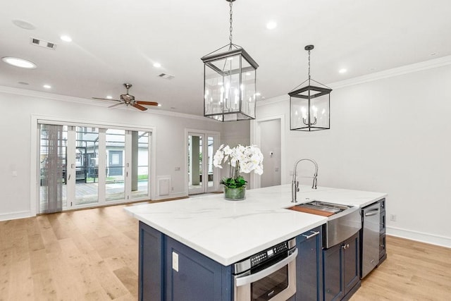 1024 Waverly St, Houston, TX 77008 - kitchen with blue cabinetry, a sink, light wood finished floors, crown molding, and open floor plan