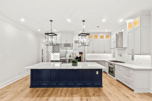 1024 Waverly St, Houston, TX 77008 - kitchen featuring wall chimney exhaust hood, stainless steel appliances, tasteful backsplash, white cabinetry, and crown molding
