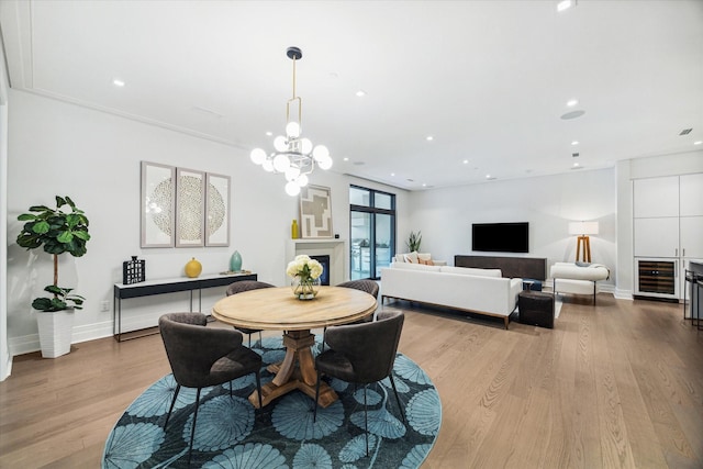 dining area with recessed lighting, light wood-type flooring, baseboards, and beverage cooler