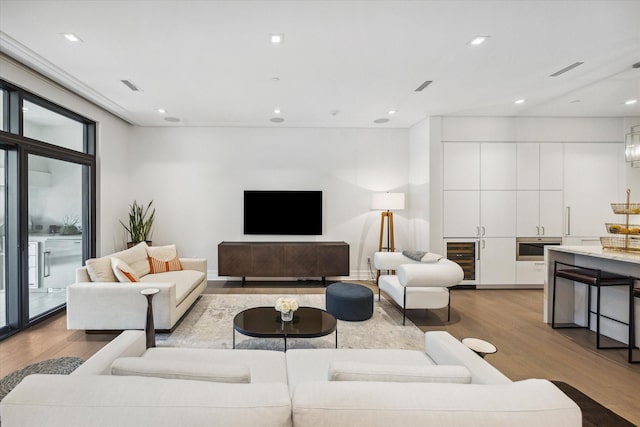 living room with wood finished floors, visible vents, wet bar, and wine cooler