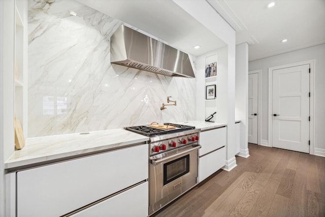 kitchen featuring wall chimney range hood, white cabinetry, wood finished floors, designer stove, and backsplash