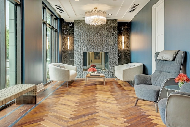 sitting room with a fireplace, a notable chandelier, and visible vents