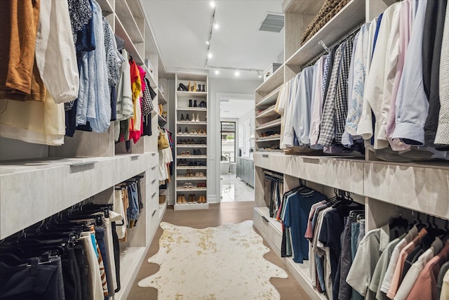 walk in closet with visible vents and wood finished floors
