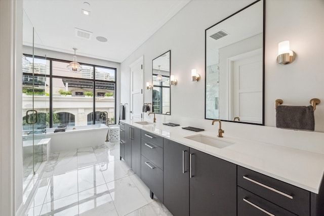 full bathroom with visible vents, marble finish floor, a sink, a freestanding bath, and double vanity