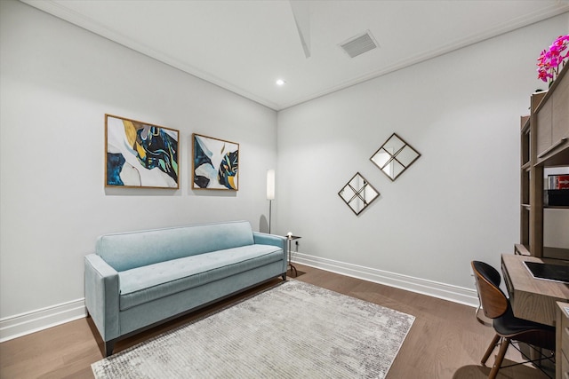 living area featuring visible vents, baseboards, and wood finished floors