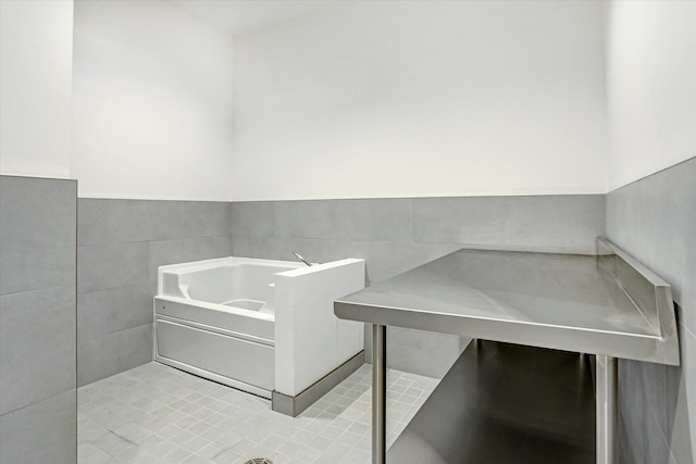 misc room with light tile patterned floors and tile walls