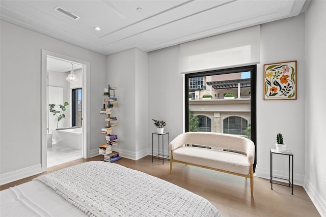 bedroom featuring visible vents, baseboards, multiple windows, and wood finished floors