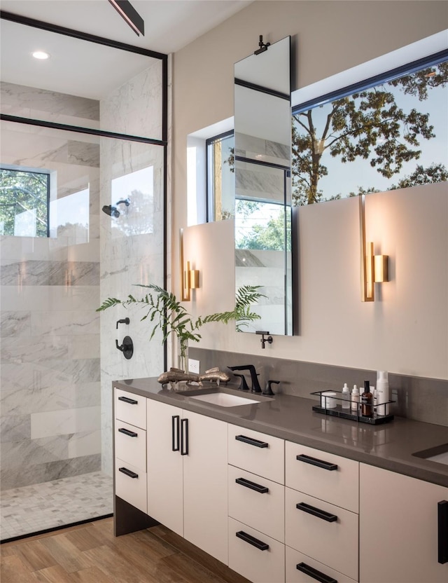bathroom with a walk in shower, wood finished floors, and vanity
